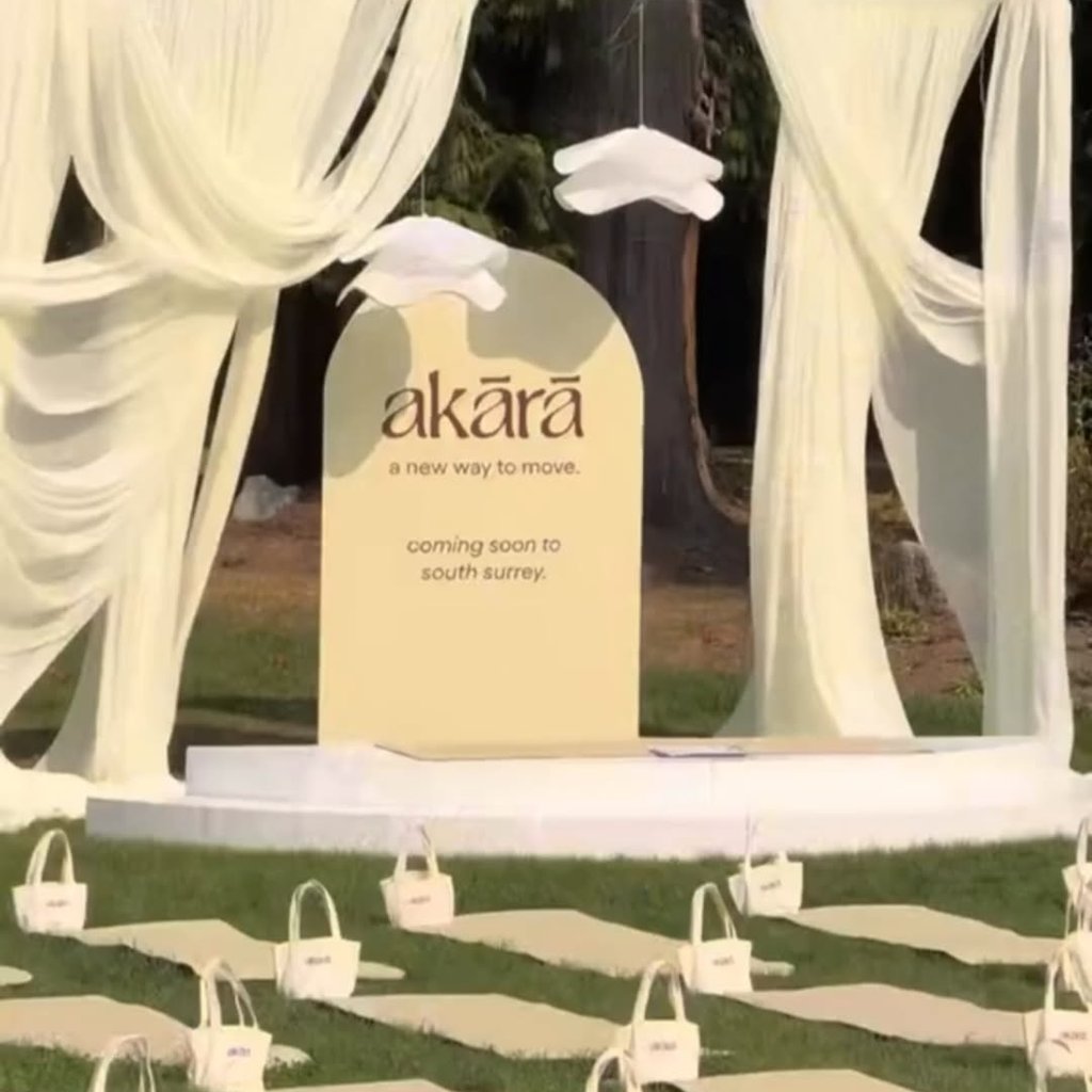 Rows of yoga mats and tote bags set up under a white canopy at Akārā-fest